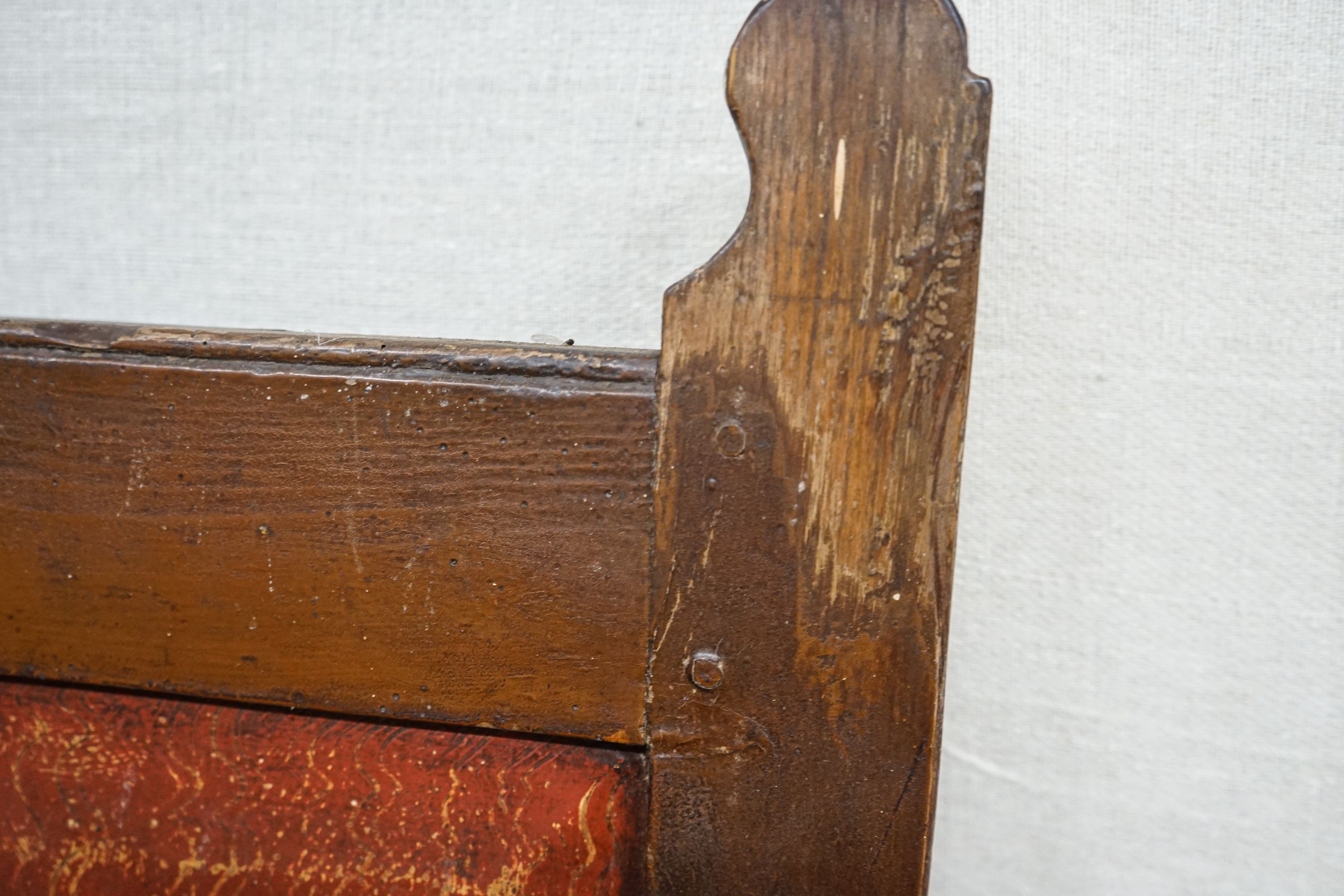 An early 19th century painted pine settle, with four panel back, scroll arms and solid seat, width 154cm, depth 49cm, height 145cm